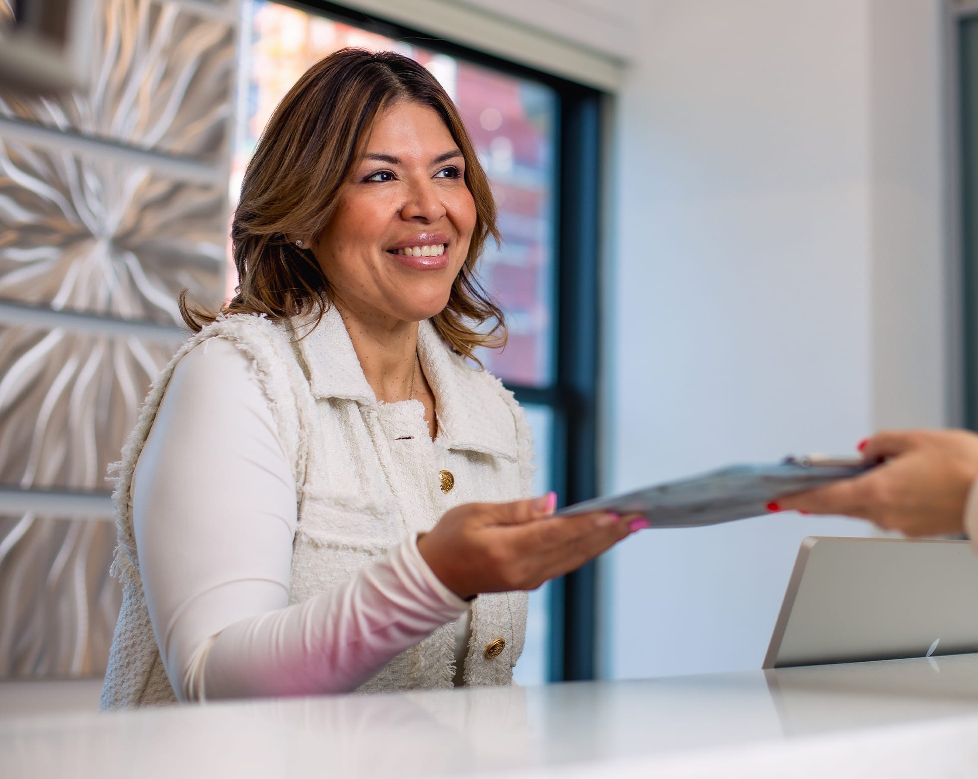 Woman smiling handing in forms